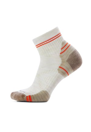 Witte enkelsok met bruine hiel en teen, voorzien van twee oranje strepen aan de boord en bijpassende oranje accenten nabij de teen en hiel.