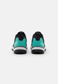 Zapatillas deportivas negras y verde azulado con parte superior de malla, suela acolchada y suela texturizada, además de una entresuela blanca para un mejor agarre y comodidad.