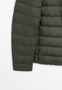 Olive green puffer jacket featuring horizontal quilted sections, a smooth texture, and a solid design. The sleeve extends slightly.