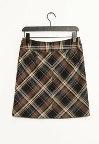 Falda corta de cuadros marrón, negro, beige y gris colgando de una percha negra sobre un fondo blanco.
