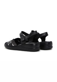 Sandali in pelle nera con suola intrecciata, design con ritagli, cinturini regolabili e soletta imbottita per il comfort.