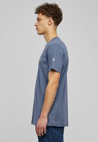 Gray cotton t-shirt with short sleeves, featuring embroidered accents on the chest and sleeve. Relaxed fit with a straight hemline.