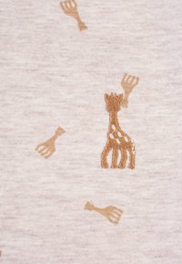 Tessuto beige chiaro con un giraffa ricamato e piccole forme di forchetta in un colore marrone, caratterizzato da una texture morbida e un motivo sottile.