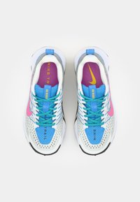 Multicolor Nike trail running shoes with a mesh upper, featuring pink, blue, and purple accents, textured sole, and turquoise laces.