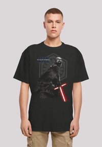 Svart bomull t-skjorte med et grafikk av en karakter med et rødt lyssverd, merket "Star Wars: The Rise of Skywalker."