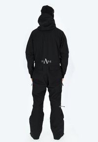 Tuta da snowboard nera da uomo con cappuccio, tasche con zip e dettagli elastici; logo visibile sul retro.