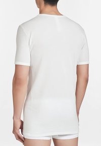 T-shirt bianco in cotone con maniche corte e colletto a giro; texture liscia e design semplice; senza motivi o accenti visibili.