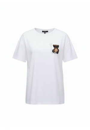 Camiseta blanca de manga corta con un pequeño osito de peluche marrón y un globo blanco en el área del pecho izquierdo.