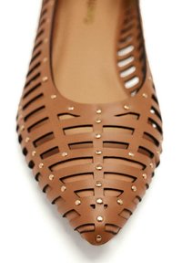 Scarpa piatta in sintetico marrone con design a reticolo ritagliato. Presenta accenti in oro e punta affusolata. Rivestimento interno liscio.
