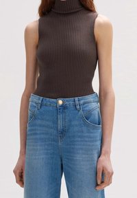 Brown ribbed sleeveless turtleneck top paired with light blue wide-leg denim jeans featuring side pockets and a front button closure.
