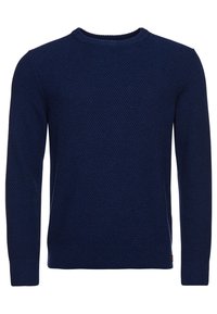 Pull tricoté bleu marine, col rond, motif texturé, manches longues, poignets et ourlet côtelés, avec un petit logo en bas sur le côté.