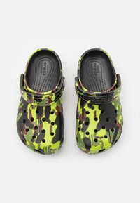 Barevné dřeváky s kamuflážním vzorem v kombinaci zelené, černé a hnědé. Vyrobeny z lehkého materiálu. Mají ventilační otvory a nastavitelné řemínky.