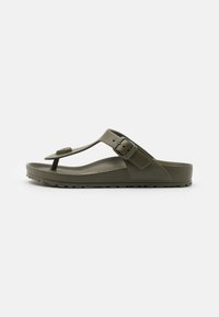 Grøn gummiflip-flop sandal med en thong-stil rem, justerbar spænde, tekstureret fodseng og en sål med riller for bedre greb.