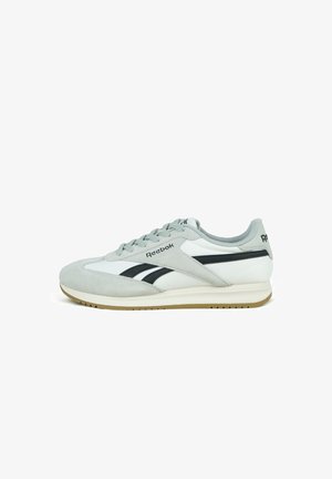 Weiße und graue Low-Top Reebok-Sneaker mit schwarzen Logostreifen und brauner Gummisohle, seitlich auf weißem Hintergrund dargestellt.