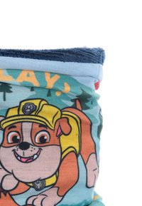 Giocattolo di peluche a tema Paw Patrol con un cane cartone animato in un cappello giallo su un morbido tessuto blu, decorato con un motivo di alberi e testi giocosi.