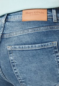 Modré džíny z denimu s texturovaným povrchem, s jemným vyblednutím, kontrastním šitím a koženou nášivkou s embosovaným nápisem "Marc O’Polo."