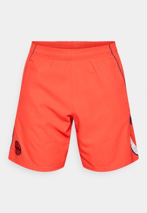 Svetlo oranžne hlače s elastičnim pasom, stranskimi žepi in črnimi logotipnimi detajli. Gladka tekstura z kontrastnimi modrimi poudarki.