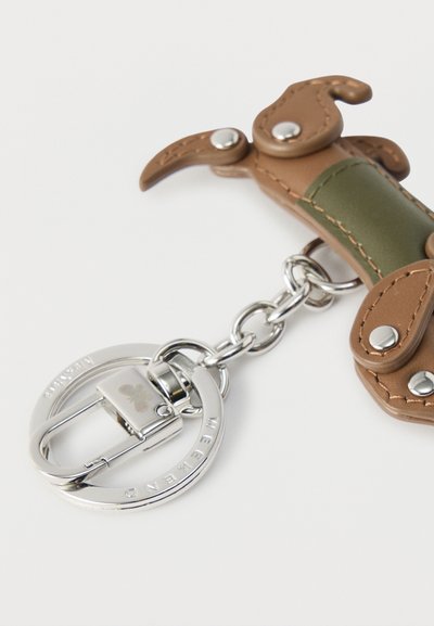 Μπρελόκ σε σχήμα σκύλου, κατασκευασμένο από ταμπά και πράσινο δέρμα, με ασημί μεταλλικές λεπτομέρειες και κλιπ για το κρέμασμα.