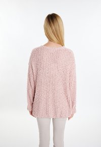 Maglione rosa chiaro con texture, dal taglio morbido, design a coste e scollatura ampia; mostrato dal retro con maniche lunghe.