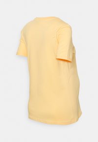 T-shirt de algodão de manga curta, de cor amarela brilhante. Design simples com decote redondo e corte reto. Sem padrões ou detalhes visíveis.
