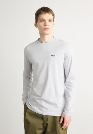 T-shirt a maniche lunghe grigio chiaro in cotone, con scollatura rotonda e un piccolo logo nero "BOSS" sul petto.