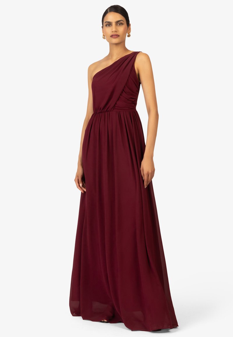Robe de soirée bordeaux à une épaule avec un tissu drapé et une taille cintrée. Modèle long avec une texture lisse. Accents minimalistes.