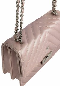 Różowa skórzana torebka z chevronowym wzorem pikowania, srebrny łańcuszek oraz srebrne zapięcie. Gładka tekstura z widocznymi detalami szycia.
