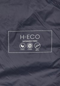 Marineblauer Stoff mit weißen Texten und Symbolen, die "H-ECO", "Nachhaltiger Stoff" sowie Begriffe für nachhaltig, umweltfreundlich und wasserabweisend anzeigen.