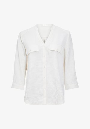 Weiße, strukturierte Bluse mit V-Ausschnitt, dreiviertel Ärmeln und zwei vorderen Taschen. Mit Knöpfen in der Mitte befestigt. Weicher Stoff.