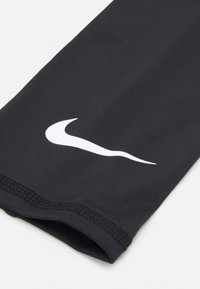 Crna sportska rukava Nike izrađena od glatkog materijala, s izraženim bijelim swoosh logotipom. Detalji šivanja duž rubova.