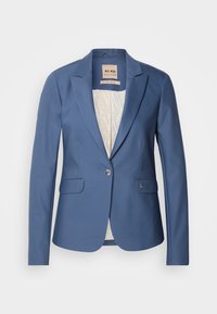 Blazer bleu pour femme sur mesure avec revers, fermeture à un bouton, poches à rabat et doublure intérieure claire à motif.