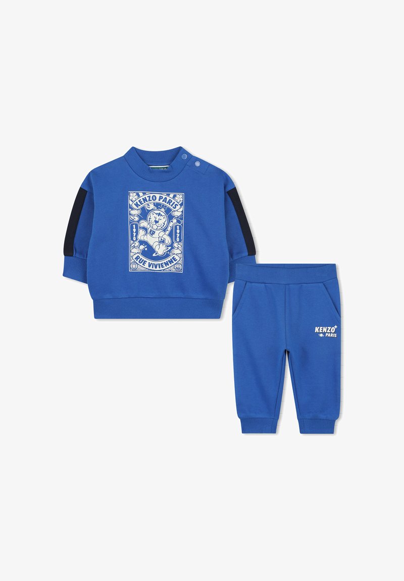 Blauwe tweedelige outfit met een langetermijn top met een grafische print en zwarte schouderaccenten, gecombineerd met bijpassende instapbroeken.