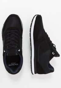 Baskets noires en mesh et daim, dotées d'un bout rond, d'une semelle en caoutchouc blanche et d'accents contrastants. Design à lacets avec détail logo.