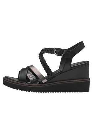 Black wedge sandal featuring braided straps, metallic accents, a textured band, and a cushioned sole with a ridged bottom for traction.
