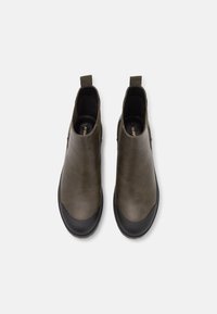 Olivově zelené kožené kotníkové boty s kulatou špičkou, černým gumovým krytem špičky a poutky pro snadné obouvání. Hladká textura a minimalistický design.