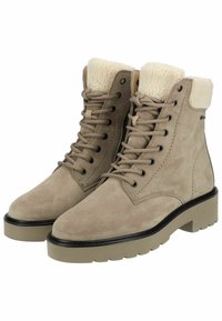 Botas de tobillo de ante beige con diseño de cordones, cuello de piel sintética, suela de goma gris gruesa y acento negro alrededor de la base.