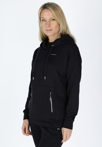 Black hoodie made of soft fabric, featuring a front kangaroo pocket, silver zipper accents, and adjustable drawstring hood.