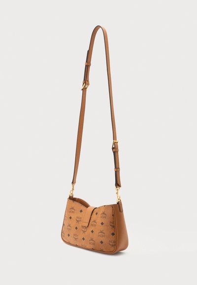 Sac bandoulière en cuir marron avec sangle réglable, ferrures dorées et motif répétitif de logo noir à l'avant et sur les côtés.