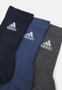 Tre par sokker i marineblå, blå og grå. Ribbet tekstur med hvidt Adidas-logo broderet på siden af hver sok.
