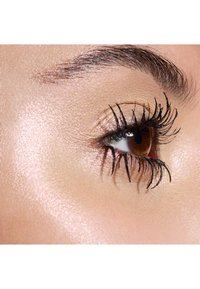 Nahaufnahme eines braunen Auges mit langen schwarzen Wimpern, das eine glatte Hautstruktur und einen Hauch von Glanz auf dem Augenlid aufweist.