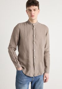 Linnen shirt in lichtbruin met een Mandarin-kraag, lange mouwen en knoopsluiting. Heeft een gestructureerde stof en een casual pasvorm.