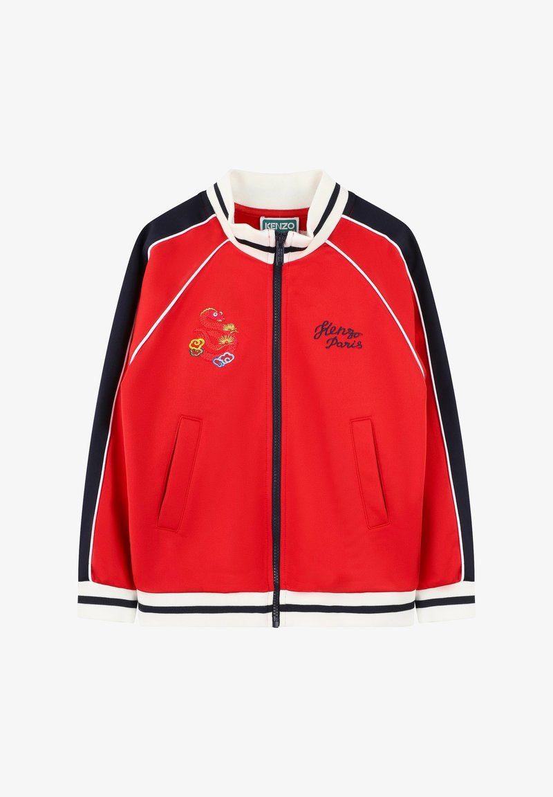 Veste zippée rouge avec accents marine, col et poignets côtelés, détails brodés, et deux poches avant. Présente un passepoil blanc le long des coutures.