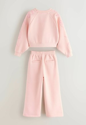 Felpa rosa chiaro con maniche raglan e dettagli stampati, abbinata a pantaloni larghi con vita elastica e tasche posteriori.