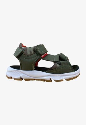 Sandalias de color verde oliva con correas de Velcro, suela acolchada, entresuela blanca texturizada y suela de goma. Presentan un forro interior de camuflaje.