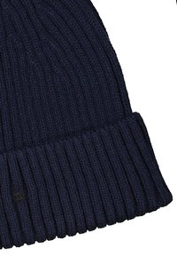 Marine gebreide beanie met een geribd ontwerp en omgeslagen boord. Gemaakt van zachte garen, met een klein zwart logo op de zijkant.