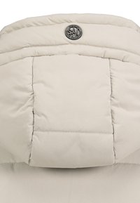 Beige gepolsterte Jacke mit Kapuze, genähten Nähten und einem kleinen runden Metalllogo in der oberen Mitte.