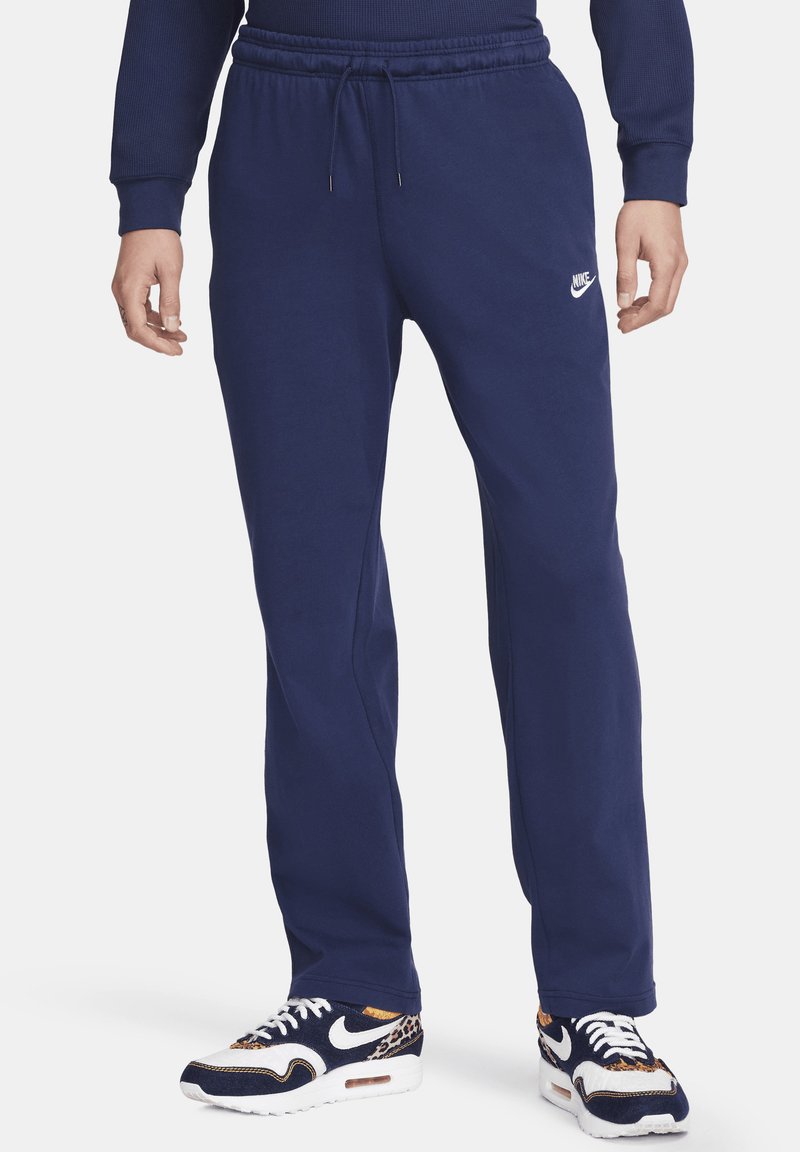 Pantalons de survêtement Nike en bleu marine, fabriqués à partir d'un tissu doux avec une taille ajustable, arborant un logo discret sur le côté gauche.