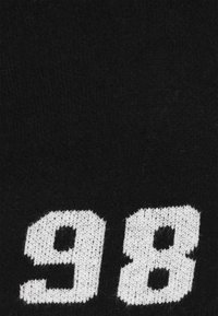 Tessuto a maglia nera con grandi numeri bianchi "9" e "8" in evidenza; morbido al tatto con una trama densa.