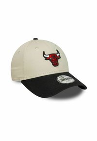 Casquette de baseball beige et noire avec un logo de tête de taureau rouge sur le devant et une visière courbée avec un autocollant.