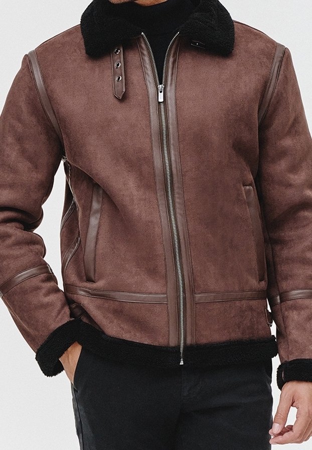 Giacca in finta pelle marrone con colletto e polsini in shearling, chiusura con zip e dettagli di cucitura verticale sul davanti e sulle maniche.